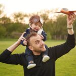 Le garçon est assis sur les épaules de l'homme.